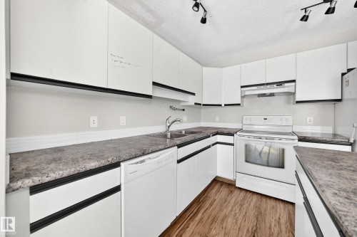 Well-appointed kitchen featuring white cabinetry, a built-in dishwasher, and a white electric range with an overhead hood - #30 300 Hooper Cr Nw, Edmonton, AB 