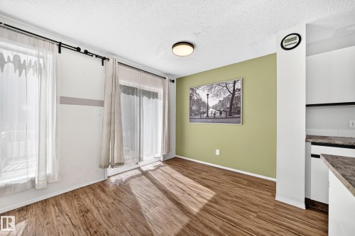 Wood-finish flooring, sliding glass door, and a kitchen counter with light-colored cabinetry - #30 300 Hooper Cr Nw, Edmonton, AB 