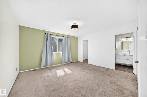 Recessed window, ceiling-mounted light fixture, and an open doorway to a bathroom featuring a modern vanity with a vessel sink - #30 300 Hooper Cr Nw, Edmonton, AB 
