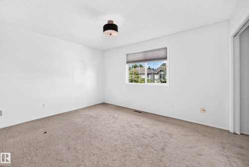 Neutral-toned carpeting, white painted walls, and a window with blinds - #30 300 Hooper Cr Nw, Edmonton, AB 