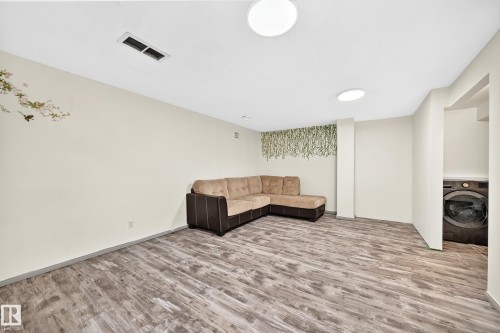 Wood-finish flooring, recessed lighting, and a dedicated laundry area with a front-loading washer - #30 300 Hooper Cr Nw, Edmonton, AB 
