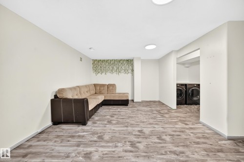 Wood-finish flooring throughout, bright recessed lighting, and a dedicated laundry area with built-in appliances - #30 300 Hooper Cr Nw, Edmonton, AB 