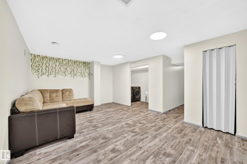 Spacious room featuring wood-finish flooring, recessed ceiling lighting, and a bi-fold closet door - #30 300 Hooper Cr Nw, Edmonton, AB 