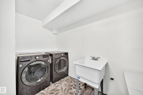 Laundry area featuring a utility sink, patterned floor tile, and white walls - #30 300 Hooper Cr Nw, Edmonton, AB 