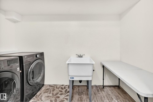 Utility sink with chrome-finish faucet, wood-finish flooring, and light-toned wall paint - #30 300 Hooper Cr Nw, Edmonton, AB 