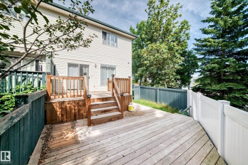 Expansive outdoor decking with wood railings and steps, featuring a vinyl privacy fence - #30 300 Hooper Cr Nw, Edmonton, AB 