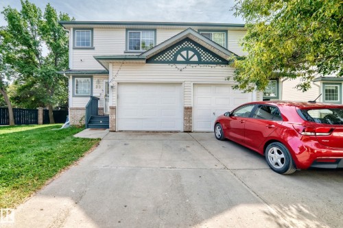 Two-story residence featuring light-toned siding and brick accents - #30 300 Hooper Cr Nw, Edmonton, AB 