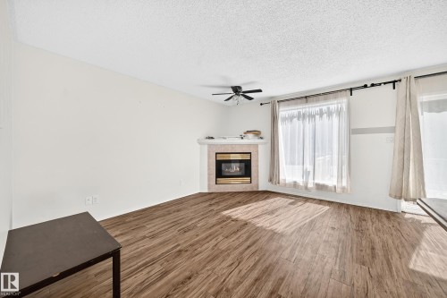 Corner fireplace with a tile surround and mantel - #30 300 Hooper Cr Nw, Edmonton, AB 