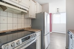 White cabinetry with brushed nickel hardware, light-toned backsplash tiling, and stone-finish countertops - 