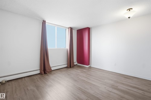 Wood-finish flooring, white walls with an accent feature wall, and a ceiling-mounted light fixture - #1115 13910 Stony Plain Rd Nw, Edmonton, AB 