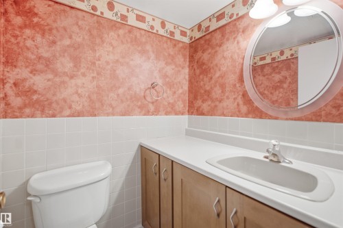 Built-in vanity with wood-finish cabinetry, integrated sink, and white countertop - #1115 13910 Stony Plain Rd Nw, Edmonton, AB 