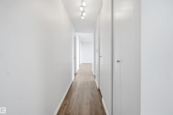 Hallway featuring wood-finish flooring, recessed lighting, and white panel doors - 
