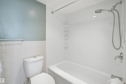 White ceramic tile wainscoting with a pale blue wall above - #1115 13910 Stony Plain Rd Nw, Edmonton, AB 