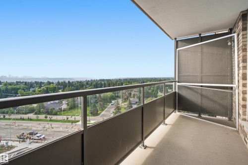 Private balcony with a concrete floor, glass and metal railings, and a brick exterior wall - #1115 13910 Stony Plain Rd Nw, Edmonton, AB 