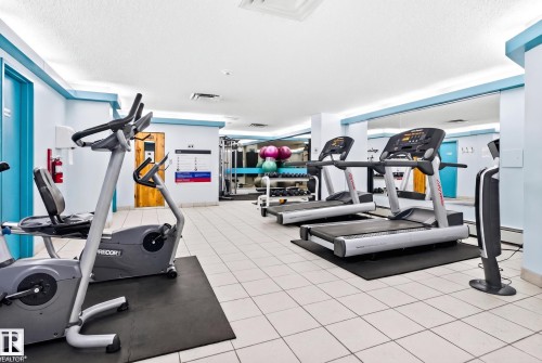 Fitness center with tile flooring, mirrored wall, and exercise equipment - #1115 13910 Stony Plain Rd Nw, Edmonton, AB 