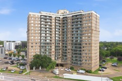 High-rise building with a brick facade and multiple balconies - 