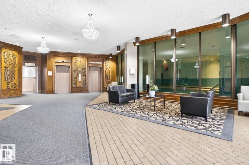 Lobby featuring decorative wood paneling, two elevators, and crystal chandeliers - #1115 13910 Stony Plain Rd Nw, Edmonton, AB 