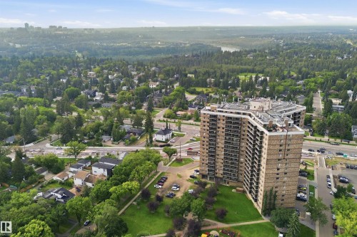 High-rise building with a stone-clad exterior, surrounding green spaces, and surface parking - #1115 13910 Stony Plain Rd Nw, Edmonton, AB 