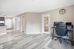 Light wood-finish flooring throughout, smooth walls, white trim, and a white door with frosted glass - 