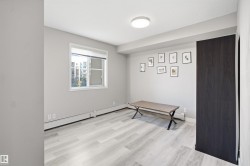 Recessed wall-mounted heating units, light wood-finish flooring, and a window with white trim - 