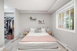 Wood-finish flooring, white trim, and a window with blinds - 