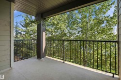 Covered balcony with a concrete floor, black metal railing, and a column accent - 