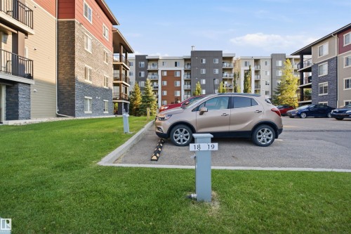 Exterior building featuring stone veneer accents and private balconies - #212 12035 22 Av Sw, Edmonton, AB 