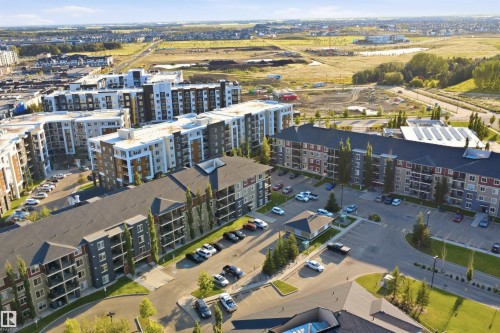 Residential buildings featuring multiple stories with balconies, surface parking, and a structured roofline - #212 12035 22 Av Sw, Edmonton, AB 