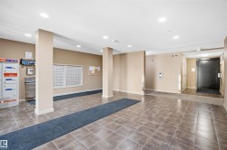 Tiled flooring with a neutral color palette, recessed lighting, and a mail area with individual mailboxes - 