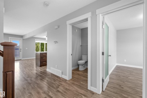 Wood-finish flooring throughout, bright white trim, and light gray wall tones - 2585 Pegasus Boulevard Nw, Edmonton, AB 