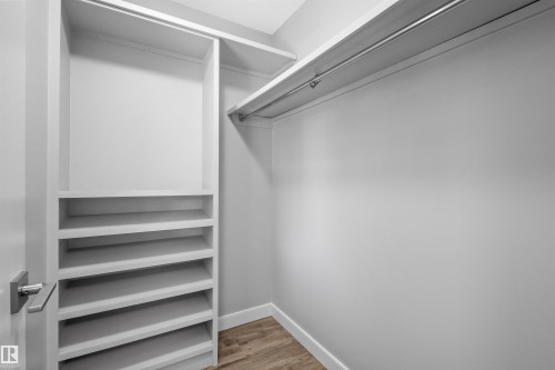 Built-in shelving, hanging rod, wood-finish flooring, and a modern door handle - 2585 Pegasus Boulevard Nw, Edmonton, AB 