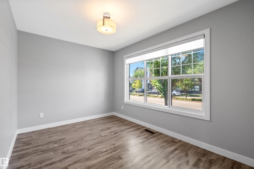 Wood-finish flooring, white trim, and a contemporary ceiling light fixture - 2585 Pegasus Boulevard Nw, Edmonton, AB 