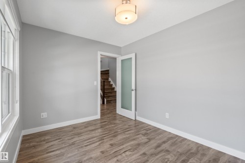 Wood-finish flooring, light gray wall paint, and a semi-flush mount ceiling light - 2585 Pegasus Boulevard Nw, Edmonton, AB 