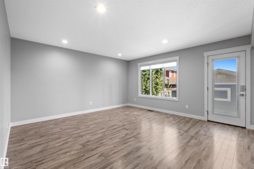 Recessed lighting, wood-finish flooring, white trim, large window, and a glass-paneled door - 2585 Pegasus Boulevard Nw, Edmonton, AB 