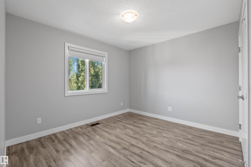 Wood-finish flooring, neutral wall color, and a window with a roller shade - 2585 Pegasus Boulevard Nw, Edmonton, AB 