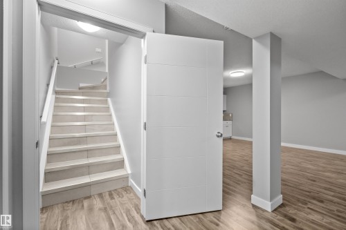 Tiled staircase with white handrail and wood-finish flooring - 2585 Pegasus Boulevard Nw, Edmonton, AB 