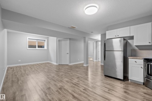 Open concept living area with wood-finish flooring, recessed lighting, and a window - 2585 Pegasus Boulevard Nw, Edmonton, AB 