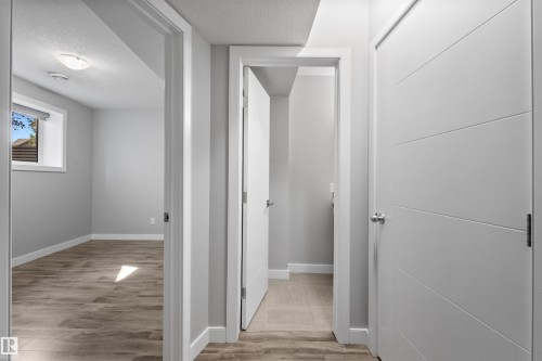Wood-finish flooring throughout, complemented by light gray wall paint and white trim - 2585 Pegasus Boulevard Nw, Edmonton, AB 
