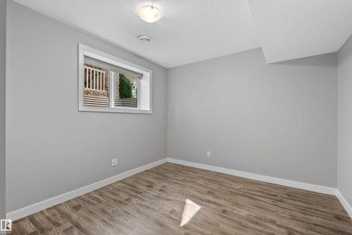 Recessed window with roller shade, wood-finish flooring, and white trim - 2585 Pegasus Boulevard Nw, Edmonton, AB 