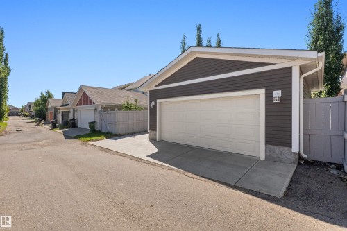 Detached garage with horizontal siding, white trim, and a concrete driveway - 2585 Pegasus Boulevard Nw, Edmonton, AB 