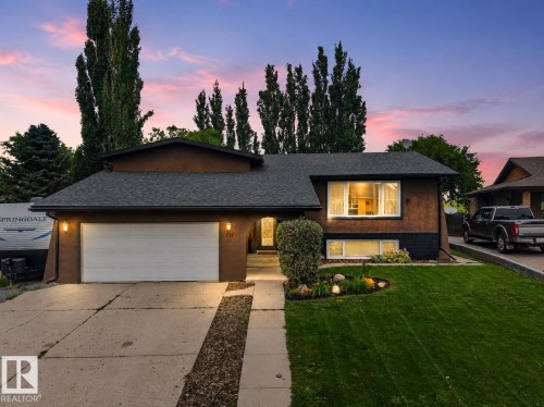Contemporary stucco exterior with a gray shingle roof and an integrated single-car garage - 131 Pine Drive, Wetaskiwin, AB - Outdoor