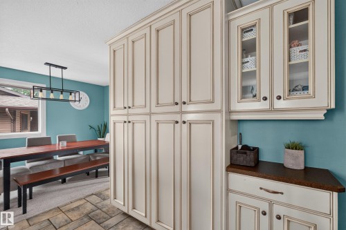 Custom cabinetry with glass-front uppers and ample storage, complemented by a coordinated lower cabinet with a dark countertop - 131 Pine Drive, Wetaskiwin, AB -  Photo Showing Other Room