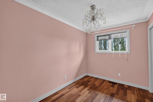 Room featuring wood-finish flooring, a window with blinds, and a decorative ceiling light fixture - 131 Pine Drive, Wetaskiwin, AB - Indoor Photo Showing Other Room