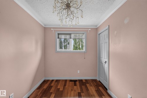 Room featuring wood-finish flooring, a window with blinds, and a white paneled door - 131 Pine Drive, Wetaskiwin, AB - Indoor Photo Showing Other Room