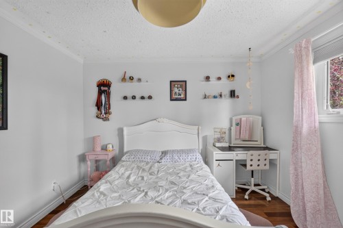 White bedroom featuring wood-finish flooring and crown molding - 131 Pine Drive, Wetaskiwin, AB - Indoor Photo Showing Bedroom