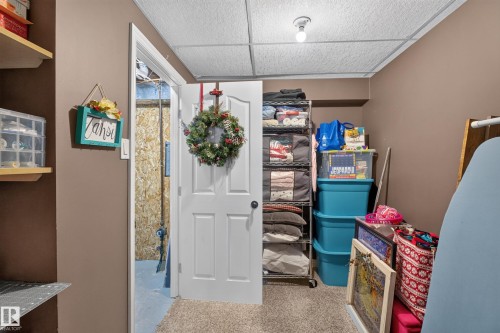 Dedicated storage room featuring neutral wall tones, a drop-tile ceiling, and carpet flooring - 131 Pine Drive, Wetaskiwin, AB - Indoor Photo Showing Other Room