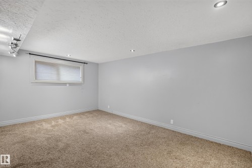 Carpeted room featuring a window with white blinds, light gray walls, and recessed ceiling lighting - 131 Pine Drive, Wetaskiwin, AB - Indoor Photo Showing Other Room