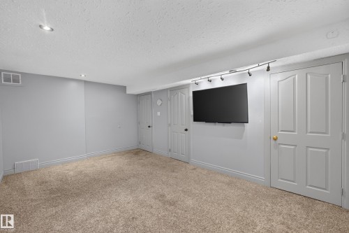 Carpeted room featuring light gray walls, white trim, recessed lighting, and track lighting - 131 Pine Drive, Wetaskiwin, AB - Indoor Photo Showing Other Room