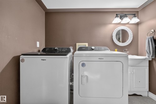 Dedicated laundry area featuring a white top-load washer and front-load dryer - 131 Pine Drive, Wetaskiwin, AB - Indoor Photo Showing Laundry Room