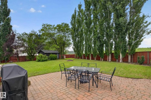 Spacious backyard featuring a paver patio and expansive lawn - 131 Pine Drive, Wetaskiwin, AB - Outdoor With Backyard